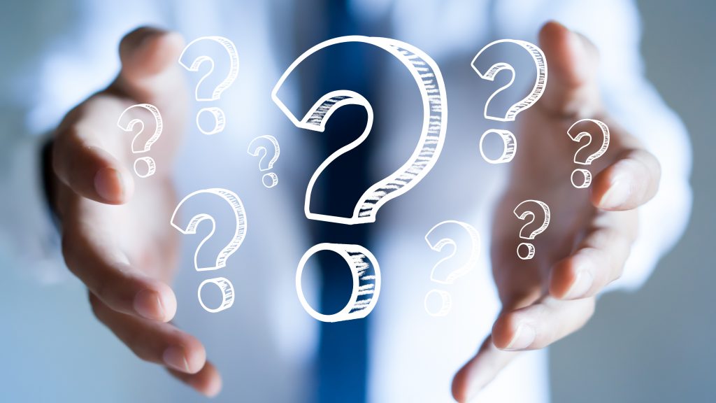 Businessman with question marks in his hand.